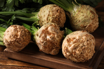 Fototapeta premium Fresh raw celery roots on wooden table, closeup