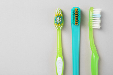 Many different toothbrushes on light background, flat lay. Space for text