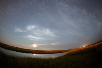 月のあかりが北海道の湿原地帯の河原を照らす