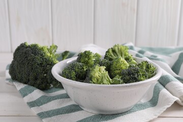 Fresh raw broccoli on white wooden table, space for text
