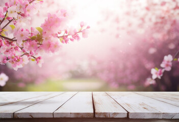 White wooden board table with defocused pink spring blossom, space for product placement