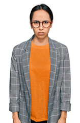 Young hispanic girl wearing business jacket and glasses skeptic and nervous, frowning upset because of problem. negative person.