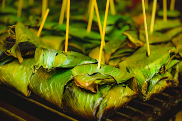 Sour pork in banana leaves on the grill