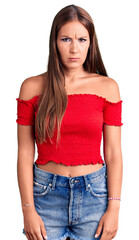Young beautiful hispanic woman wearing casual clothes skeptic and nervous, frowning upset because...