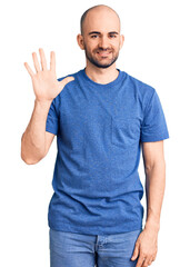 Young handsome man wearing casual t shirt showing and pointing up with fingers number five while smiling confident and happy.
