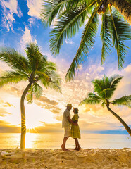 A couple of men and women hugging and kissing on the beach during sunset in Phuket during vacation, a beach with white sand and palm trees Bang Tao Beach Phuket Thailand.