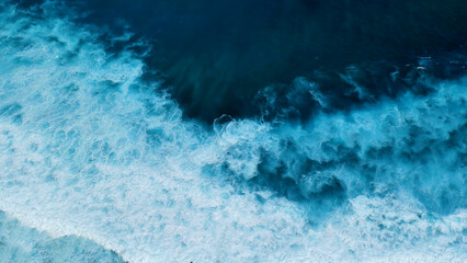 Turquoise ocean sea water white wave pattern splashing deep blue sea. Seascape dark ocean background wave splash on rock. Tropical sea beach in summer seaside outdoor. Water Surface blue wave pattern