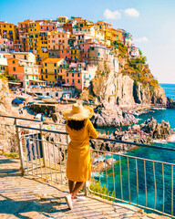 Asian women visiting Manarola in Cinque Terre Italy, Manarola Village, Cinque Terre Coast Italy. Manarola is a beautiful colorful town of La Spezia, Liguria, and one of the five Cinque Terre - obrazy, fototapety, plakaty