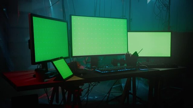 Monitors with green screen arranged side by side on desk