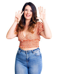 Beautiful young brunette woman wearing casual clothes showing and pointing up with fingers number nine while smiling confident and happy.