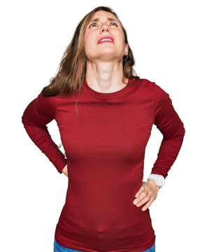 Young blonde woman wearing casual clothes suffering of neck ache injury, touching neck with hand, muscular pain