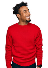 Fototapeta premium Young african american man with beard wearing casual winter sweater looking away to side with smile on face, natural expression. laughing confident.