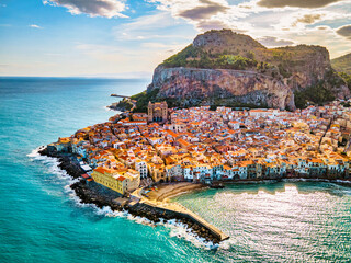 Drone view from above at the old town of Cefalu at sunset, medieval village of Sicily island, Province of Palermo, Italy. Europe. Cathedral of Cefalu