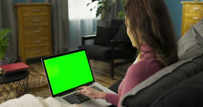 The woman's facial expressions and occasional nods suggest she might be watching an engaging and informative video, such as a tutorial or a thought-provoking TED Talk.