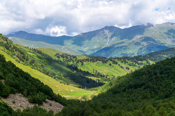 Naklejka na ściany i meble The valley of the Malaya Dukka River surrounded by the mountains of the North Caucasus and the tourist trail to the Dukka Lakes on a sunny summer day, Arkhyz, Karachay-Cherkessia, Russia