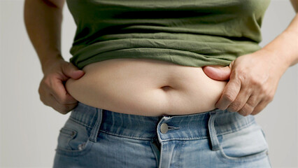 close up of woman hand pinching excessive belly fat
