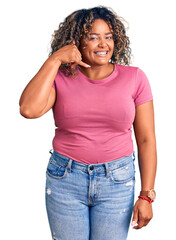 Young african american plus size woman wearing casual clothes smiling doing phone gesture with hand and fingers like talking on the telephone. communicating concepts.