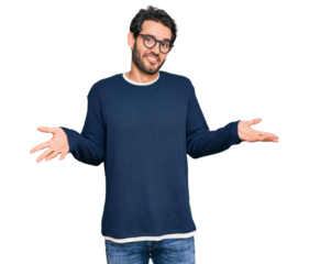 Young hispanic man wearing casual clothes and glasses clueless and confused expression with arms and hands raised. doubt concept.