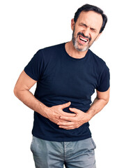Middle age handsome man wearing casual t-shirt with hand on stomach because nausea, painful disease feeling unwell. ache concept.