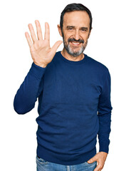 Fototapeta premium Middle age hispanic man wearing casual clothes showing and pointing up with fingers number five while smiling confident and happy.