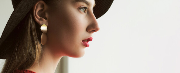 Accessories trend. Female jewelry. Beautiful elegant sensual woman in red lipstick black hat golden...
