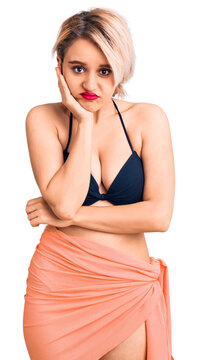 Young beautiful blonde woman wearing bikini thinking looking tired and bored with depression problems with crossed arms.
