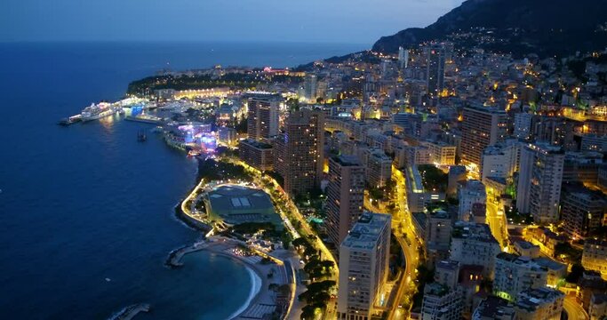 Aerial Backward Beautiful View Of City By Sea At Night - Monte Carlo, Monaco