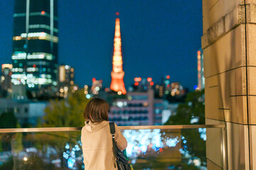 Traveler with bag visiting Roppongi Hills Christmas Illumination during winter season, happy tourist woman stands on a christmas market in Tokyo, Japan. Travel, holiday and celebrations concept