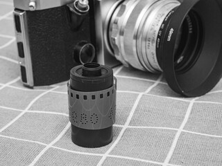 classic 135 film cassette with retro camera background  