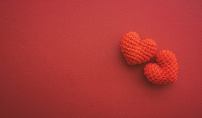 Two red hearts are placed on dark red paper with copy space. Love and Valentines day concept