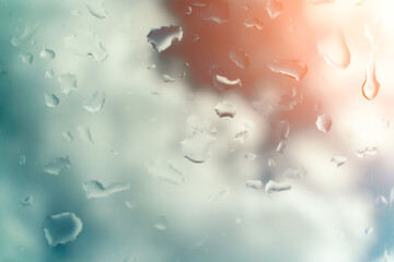 Water drops on glass against blue sky, rainy season concept. Window view background screensaver