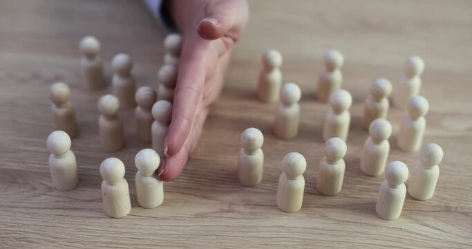 Woman hand separates groups of white figures of people