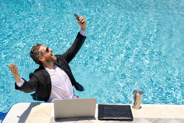 Businessman and Summer. Hot excited businessman in pool. Businessman in suit work online in beach. Travel and business. Crazy excited office worker. Excited businessman work on summer.