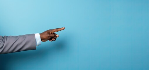 A man's hand pointing at a blue wall with an image of a space for text.
