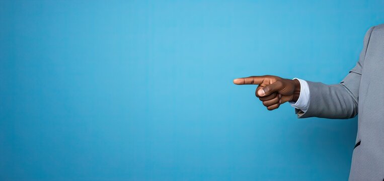 A man's hand pointing at a blue wall with an image of a space for text.