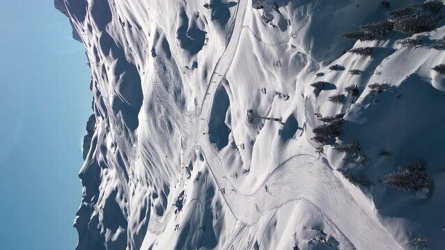 Skiers skiing runs at Avoriaz Ski Resort, French Alps, aerial, vertical format.