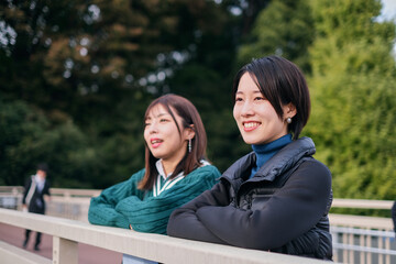 Naklejka premium 笑顔で話をする親友の女性二人