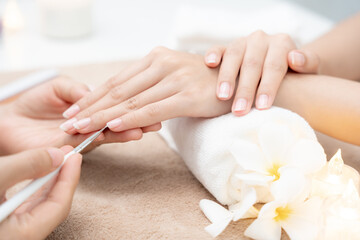 Woman receive care service by professional Beautician Manicure at spa centre. Nail beauty salon use nail file for Glazing treatment. manicurist make nail customer to beautiful. body care spa treatment