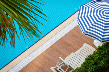 Chair and umbrella near the pool in the hotel. - 687815096