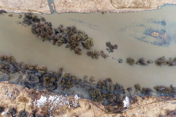 A river overflowing its banks during the spring flood, aerial view