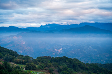 Fototapeta na wymiar There are layers of white clouds floating over the valley villages. Ginger Garden Agritourism Area, Miaoli County, Taiwan.