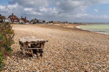 The pebble beach in Pevensey Bay, East Sussex, England, with two pallets nailed one on top of the...
