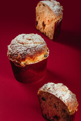 Traditional Italian Christmas cake Panettone. Artisan Pastry on red background. Close up pastry texture.