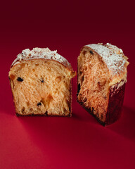 Traditional Italian Christmas cake Panettone. Artisan Pastry on red background. Close up pastry texture.