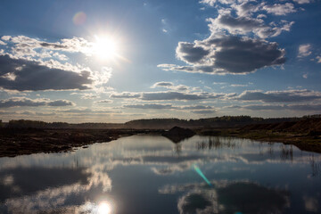 Rare clouds in the blue sky that are reflected in the water surface of the reservoir
