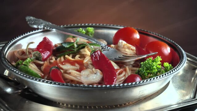 Pasta with vegetables and spices, on the table, in a plate against an old background. Ready food.