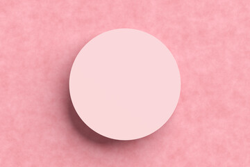 Top view of an empty circular pink podium or platform on textured pink background.