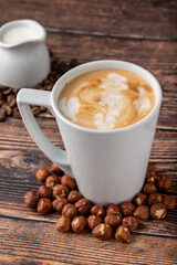 Hazelnut latte in white glass on wooden table