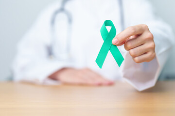Doctor holding Teal Ribbon for January Cervical Cancer Awareness month. Uterus and Ovaries, Cervix, Endometriosis, Hysterectomy, Uterine fibroids, Reproductive, Healthcare and World cancer day - obrazy, fototapety, plakaty