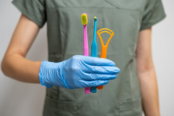 Toothbrushes and Interdental Toothbrushes in dentists hand in rubber gloves